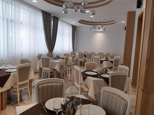a dining room with white tables and chairs at Hotel River in Borşa
