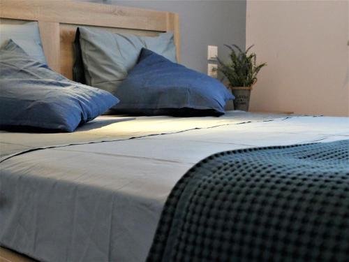 a large bed with blue pillows on top of it at Villa Lelova in Mitikas