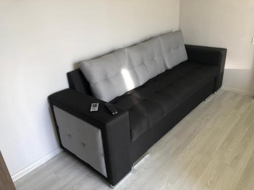 ein schwarzes und graues Sofa in einem Zimmer in der Unterkunft Люкс1 in Uschhorod