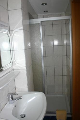 a white bathroom with a sink and a shower at Apartment Waldhaus Opitz in Zell am See