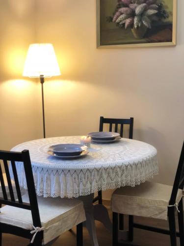 a table with a white table cloth on it with two chairs at Tulipán Villa Panzió in Szolnok