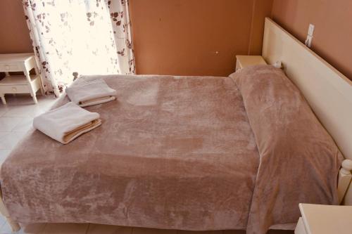 a bed with a blanket on it in a room at Family Studios in Marathias