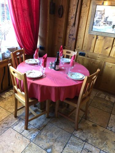 a dining room table with a pink table cloth on it at Hôtel Restaurant de la Chaussée in Briançon