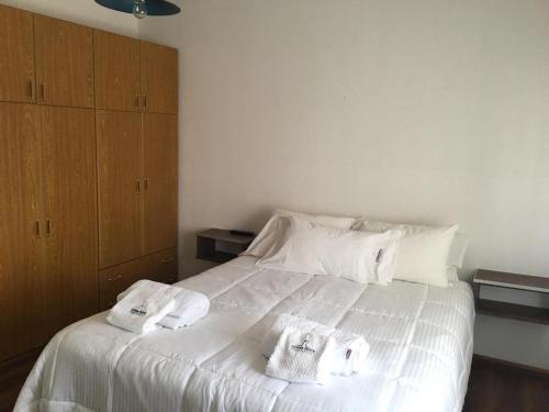 a bedroom with a white bed with towels on it at TOWER ROCK PUERTO DESEADO SUPERIOR 2 in Puerto Deseado