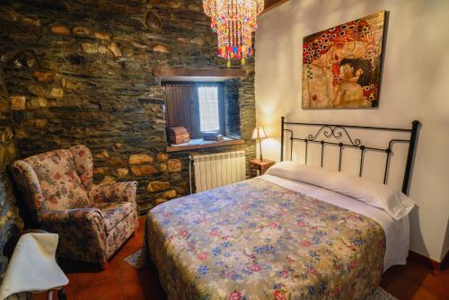 a bedroom with a bed and a chair at Dos Puentes in Vega de Espinareda