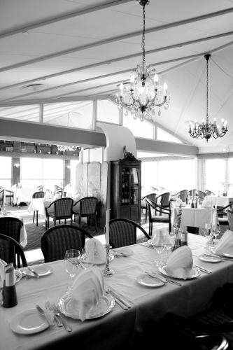 a dining room with a table and chairs and a chandelier at Montra Odder Parkhotel in Odder