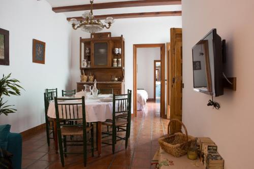 a dining room with a table and chairs and a tv at Las 9 Candelas alojamiento en el centro de Yecla in Yecla