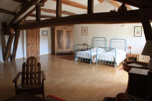 a bedroom with two beds in a room with wooden floors at Abbaye de Capservy in Villardonnel