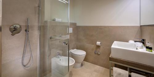 uma casa de banho com um chuveiro, um WC e um lavatório. em Park Hotel & Residence by The Cube em Fidenza