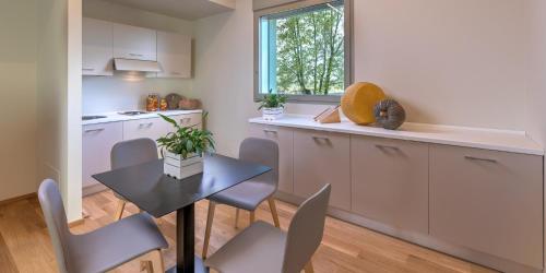a kitchen with a table and chairs in a kitchen at Park Hotel & Residence by The Cube in Fidenza