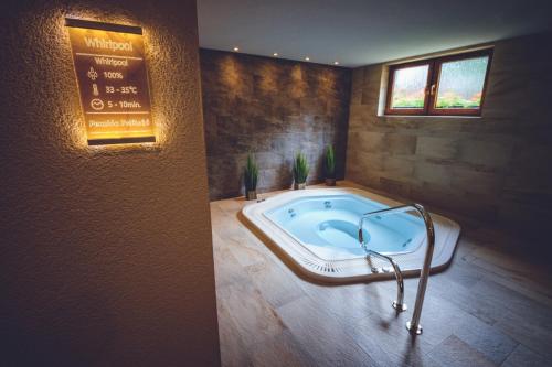 a jacuzzi tub in a room with a sign at Penzion Pribisko in Zuberec