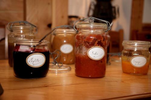 a group of jars of jam on a wooden table at Hôtel Restaurant de la Chaussée in Briançon