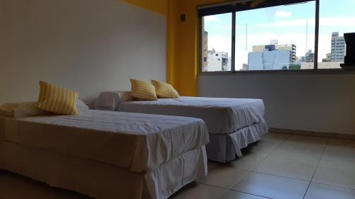 a room with two beds and a couch and a window at LAS PIEDRAS DESIGN II in San Miguel de Tucumán