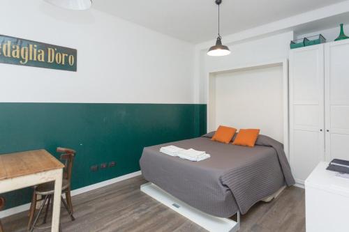 un letto in una camera con parete verde di Lust Studio Naviglio a Milano