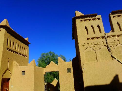 a building with a blue sky in the background at Kasbah Les Nomades in Skoura