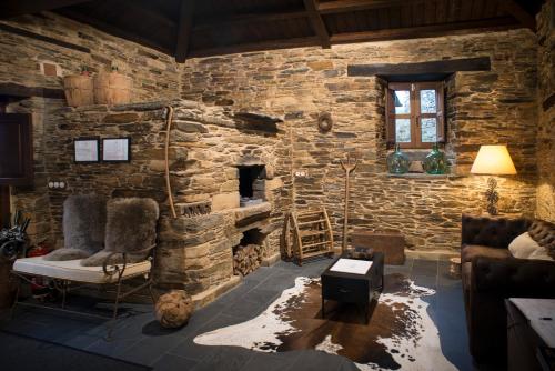 a living room with a stone wall at Aldea Rural y Gastro Restaurante Casona de Labrada in Labrada