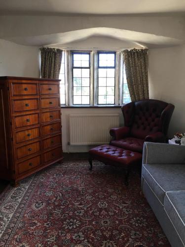a living room with a couch and a dresser at Great House Guest House in Llantwit Major