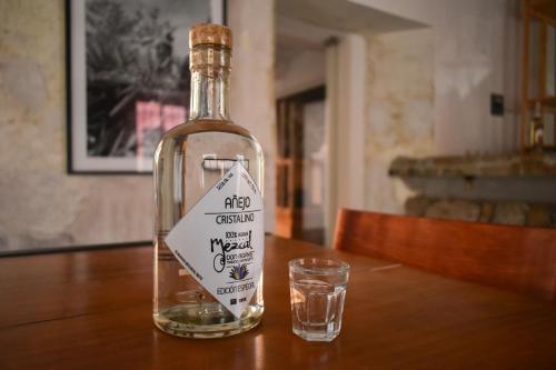 een fles alcohol zittend op een tafel met een glas bij HOTEL CASA SANTO TOMAS in Oaxaca City