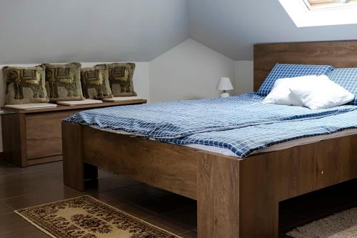 a bedroom with a bed with a blue comforter at Győri vendégház in Demjén