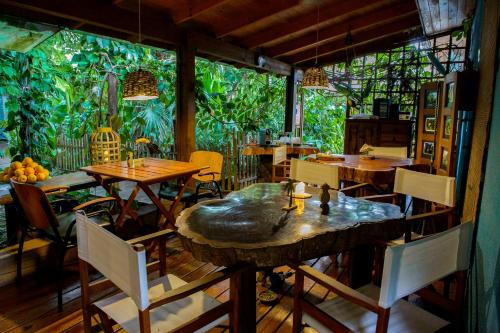 a restaurant with tables and chairs and a large window at Secret Garden Iguazu in Puerto Iguazú