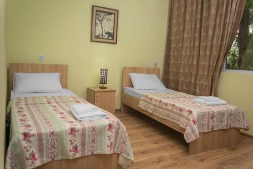 1 dormitorio con 2 camas y ventana en Holiday Cottage, en Ureki