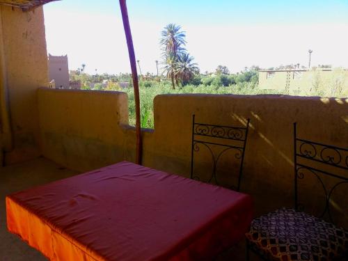 Habitación pequeña con cama y ventana en Kasbah Les Nomades, en Skoura
