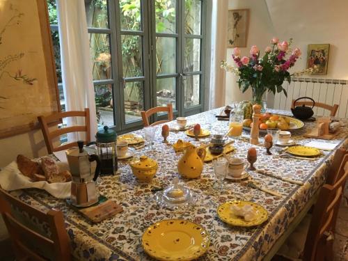 une table de salle à manger avec des assiettes jaunes et de la nourriture dessus dans l'établissement Les Asphodèles Amélie, à Saint-Hippolyte-du-Fort