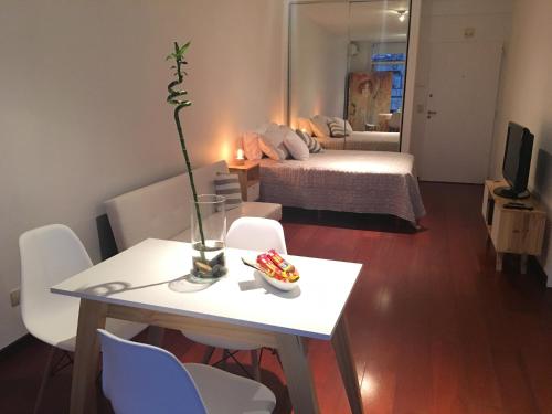 uma sala de estar com uma mesa e um quarto com uma cama em Recoleta Apart Swim & Relax em Buenos Aires