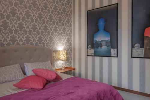 a bedroom with a bed with a purple blanket and two pictures at Residenza Hermitage in bedizzol