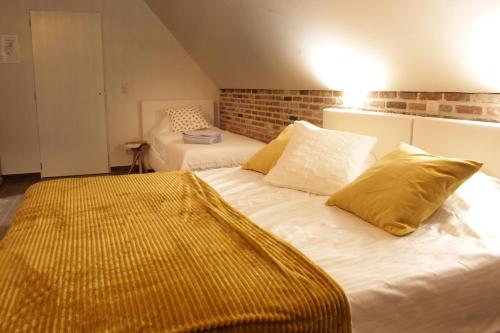 a bedroom with two beds with yellow pillows at Casa della Nonna in Zwalm