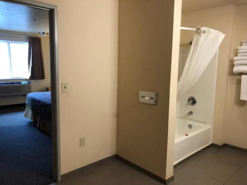 a room with a bathroom with a shower and a tub at Super 8 by Wyndham Woodburn in Woodburn