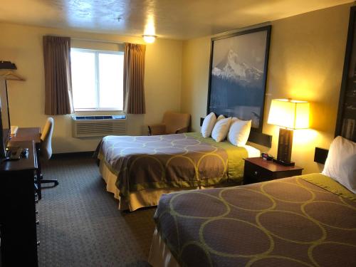 a hotel room with two beds and a window at Super 8 by Wyndham Woodburn in Woodburn