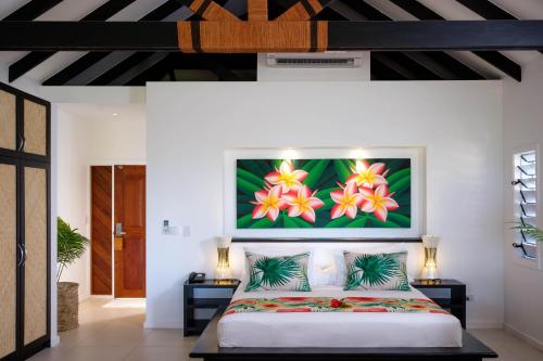 a bedroom with a bed with a painting on the wall at Lomani Island Resort & Spa in Malolo Lailai