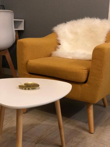 a living room with a chair and a table at Le studio d'Angèle in Bruz