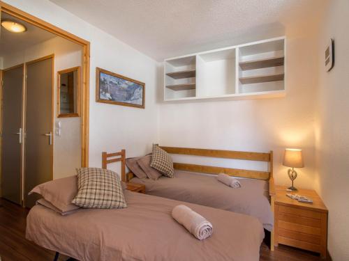 une chambre avec deux lits et une table avec une lampe dans l'établissement 26 Praz de l'Ours Vallandry - Paradiski, à Peisey-Nancroix