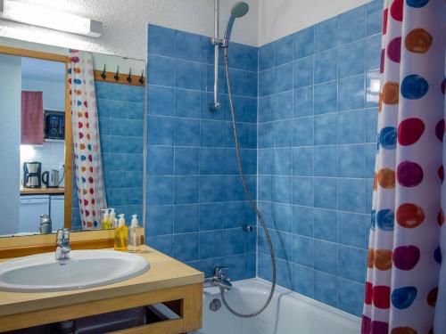 La salle de bains est pourvue de carrelage bleu, d'un lavabo et d'une douche. dans l'établissement 26 Praz de l'Ours Vallandry - Paradiski, à Peisey-Nancroix