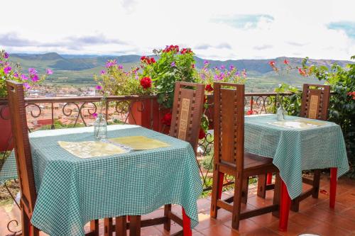 two tables and chairs on a balcony with a view at Cabaña El Mirador Vallegrande in Vallegrande