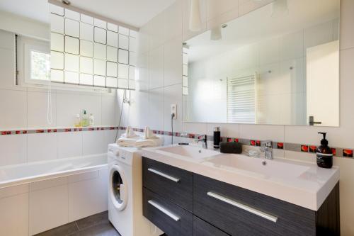 a white bathroom with a washing machine and a sink at Le Belpierre in Colmar