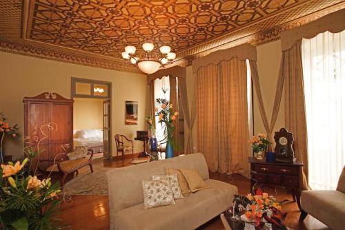 a living room with a couch and a coffered ceiling at Hotel Carvallo in Cuenca