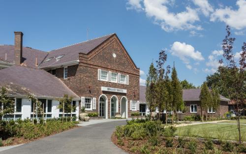 a large brick house with a driveway at Brassey Hotel - Managed by Doma Hotels in Canberra