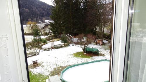 a view from a window of a yard with snow at Ferienhaus-Römerthurm in Schöder