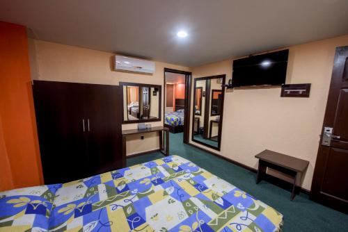 a hotel room with a bed and a mirror at Oaxaca Inn Reforma in Oaxaca City