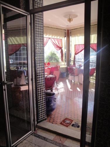 a glass door leading into a room with a dining room at Hôtel Tijani in Fès