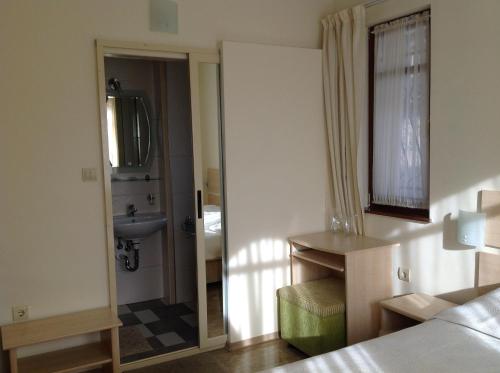 a bedroom with a bed and a sink and a mirror at Family Hotel Saint Nikola and Free parking in Nesebar
