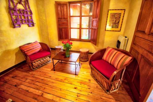 a living room with two chairs and a table at Hotel Casa Encantada in Pátzcuaro