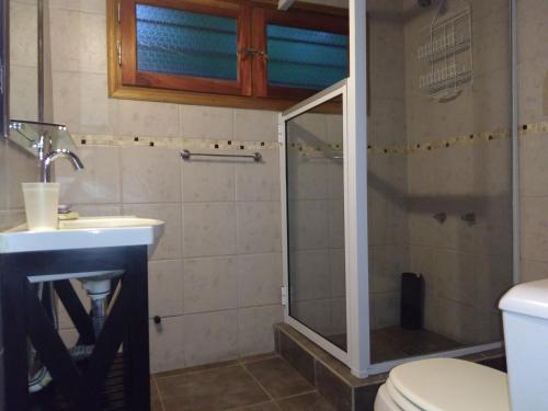 y baño con ducha, lavabo y aseo. en Cabañas Altos del Bosque en Mar del Plata