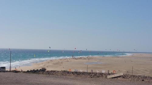 a beach with a bunch of people in the water at Apartamento Esquinzo Jandía in Playa Jandia