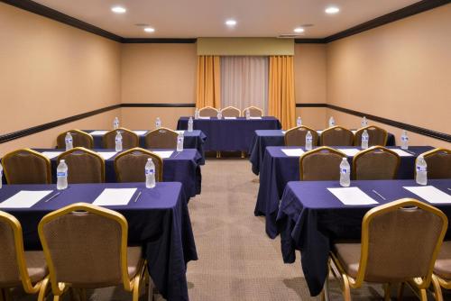 a conference room with blue tables and chairs at Hotel Chino Hills in Chino Hills