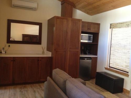 a living room with a couch and a mirror at Stone Canyon Inn in Tropic