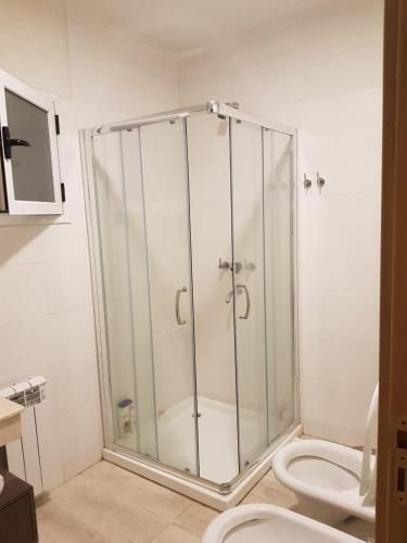 a bathroom with a glass shower with a toilet at la casa de los pájaros in San Pedro
